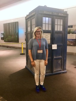 Kelly standing in front of a life-size Tardis (blue Police Box)